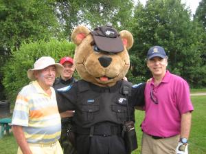 Police mascot Flick with his trusty sidekick Sargent Bryan Cunningham conduct a golfers ID check on George and Glenn J. Nashen
